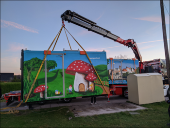 Ein bunte Stationsshülle wird von einem Kran abgesetzt