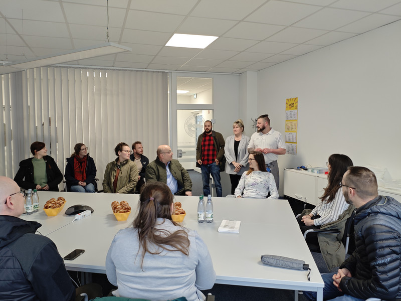 Teilnehmende des Arbeitskreises Nachhaltigkeit erhalten in einem Raum des Werks von Lieken eine Sicherheitseinweisung vor der Werksführung