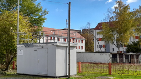 Weißer Container, im Hintergrund Wohnhäuser