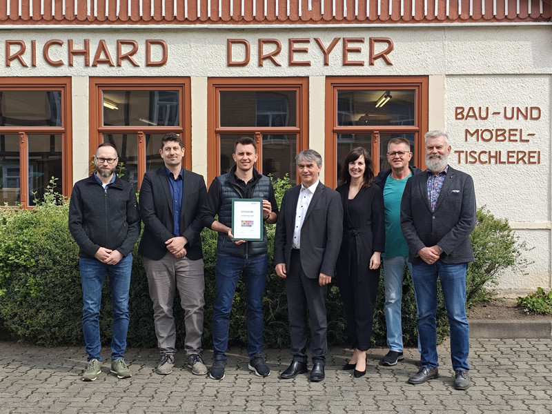 Staatssekretär Dr. Eichner und Dorit Zieler von der Handwerkskammer Magdeburg überreichen die Urkunde für den Nachhaltigkeitscheck an Herrn Dreyer.