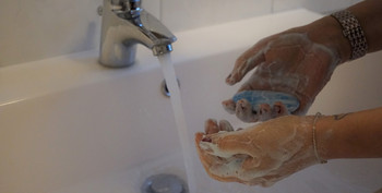 Hände werden unter einem Wasserhahn gewaschen