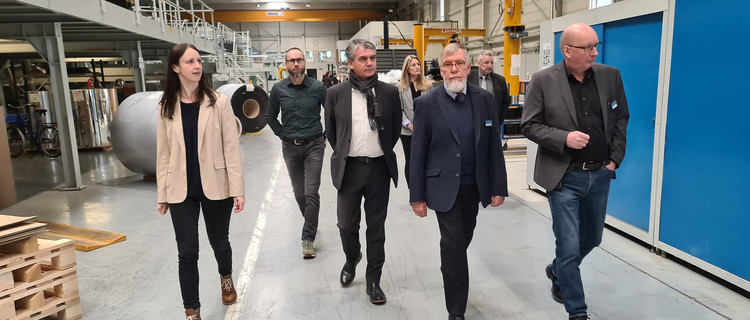 Die am Besuch Teilnehmenden besichtigen die Werkshalle.