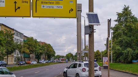 Gerät mit Solarmodul an einem Mast an einer mehrspurigen Straße